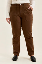 Mahogany high-waist plus size jeans featuring slim-straight legs, large utility pockets, and double-rolled cuffs paired with black loafers.