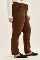Mahogany high-waist plus stretch jeans with slim-straight leg, utility pockets, and rolled cuffs paired with black mules.