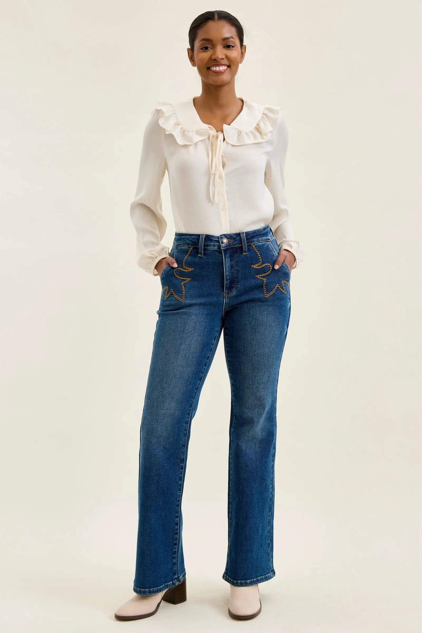 Judy Blue Daisy mid-rise tummy-control bootcut jeans in blue denim with western stitching.