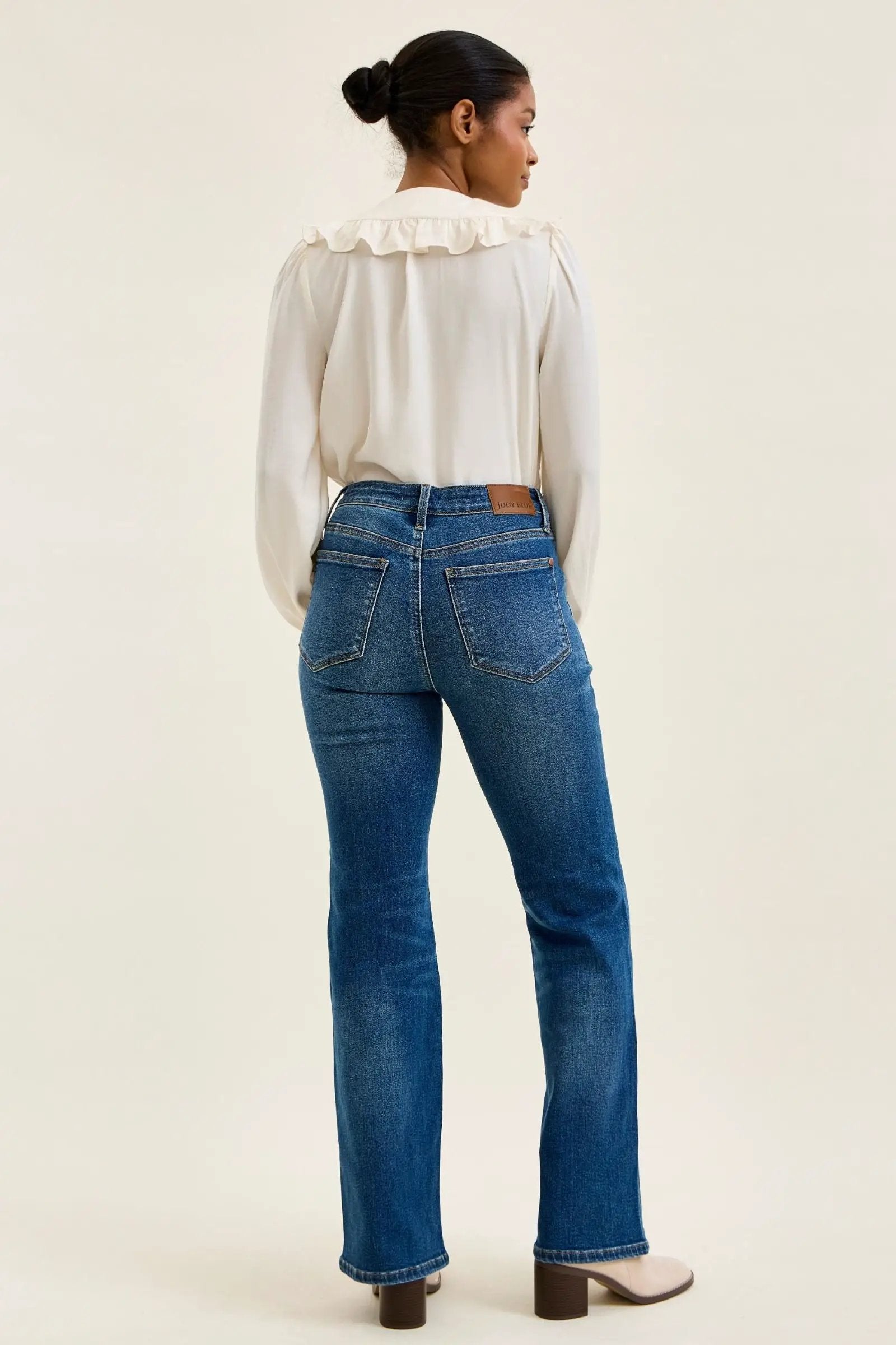 Judy Blue Daisy mid-rise tummy-control bootcut jeans with western stitching, back view showing pockets and leather patch.