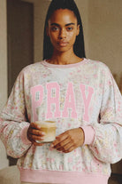 Graphic sweatshirt by Grateful Threads Boutique featuring pink PRAY on a floral granny-quilt pattern.