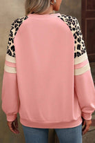 A pink sweatshirt with leopard print on the sleeves.