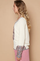 Cream floral-cuffed long-sleeve top.