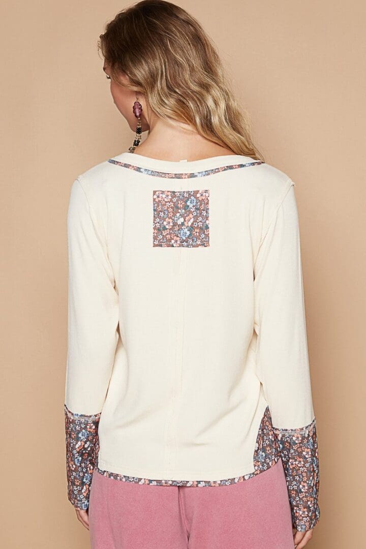 Cream floral-trimmed long-sleeve top.