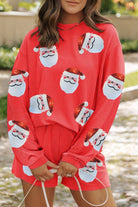 A woman in red santa clause pajamas standing on the street.