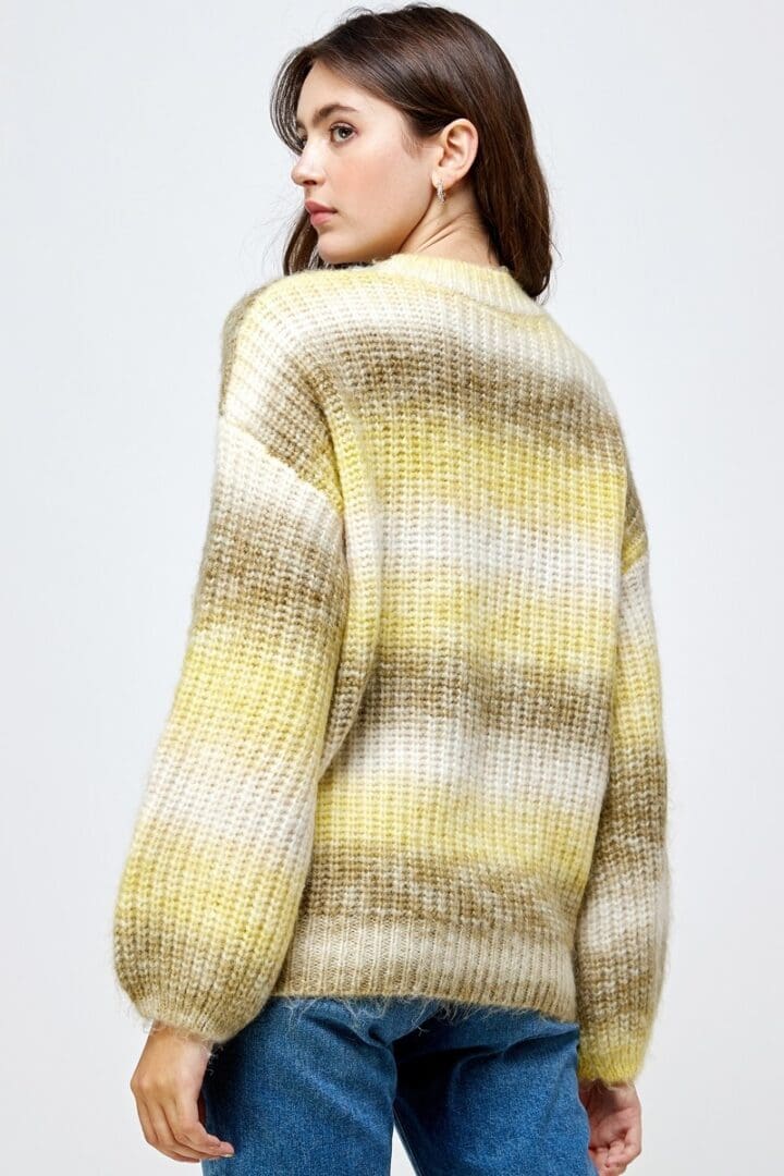 A woman wearing a yellow and white sweater.