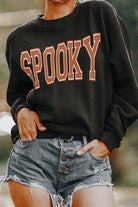 A person wearing shorts and an oversized sweatshirt.