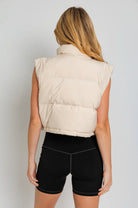 Beige sleeveless puffer vest, back view.