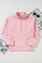 A pink sweater with a zipper on the front.