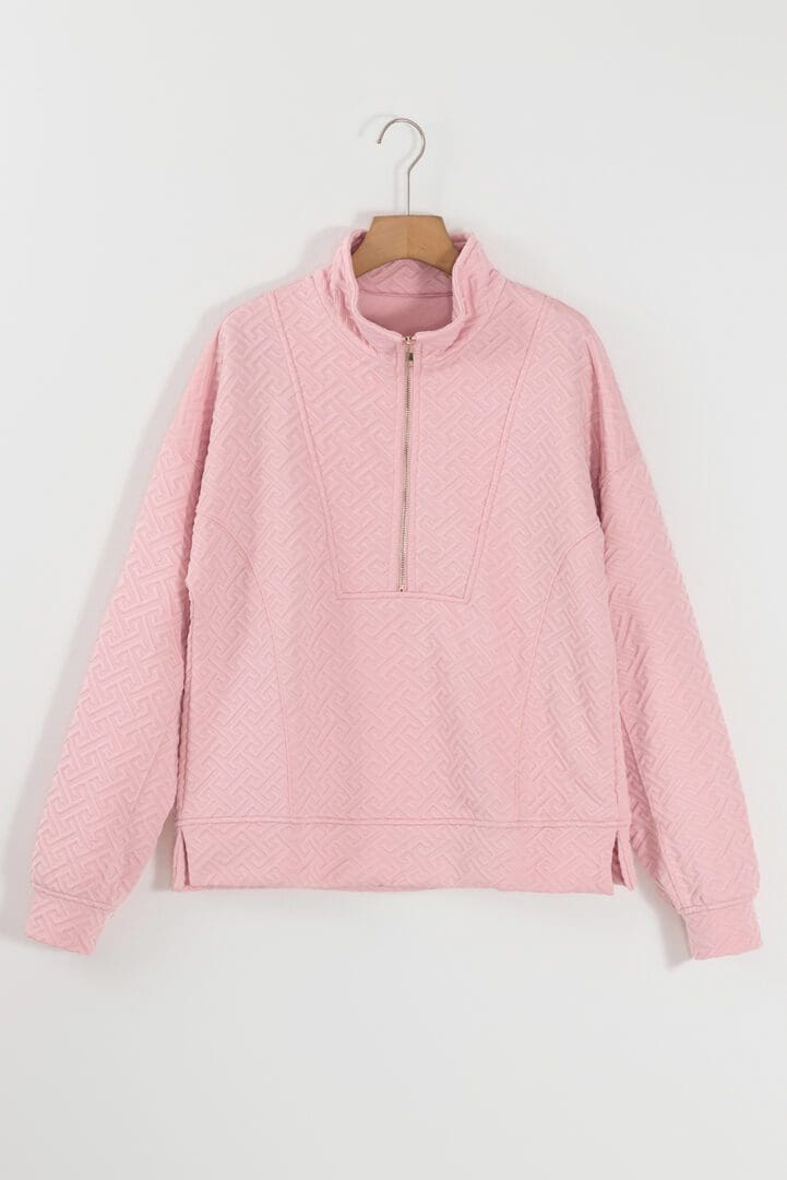 A pink sweatshirt is hanging on the wall.