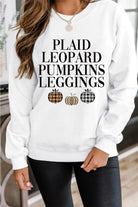 A woman wearing a white sweatshirt with plaid leopard pumpkins leggings.