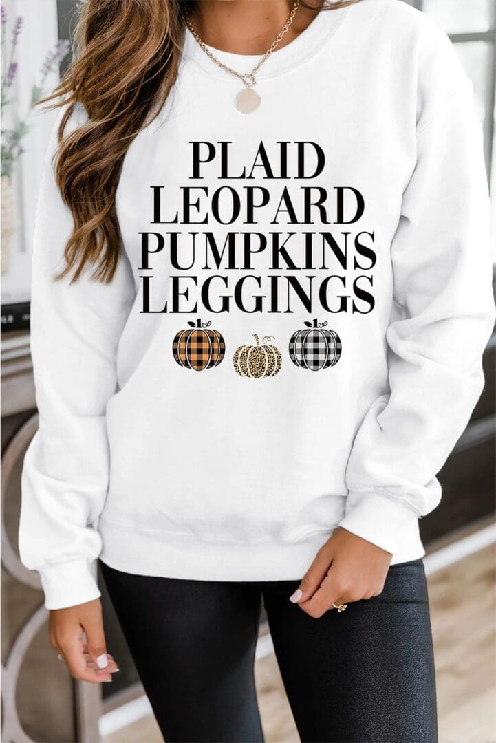 A woman wearing a white sweatshirt with plaid leopard pumpkins leggings.