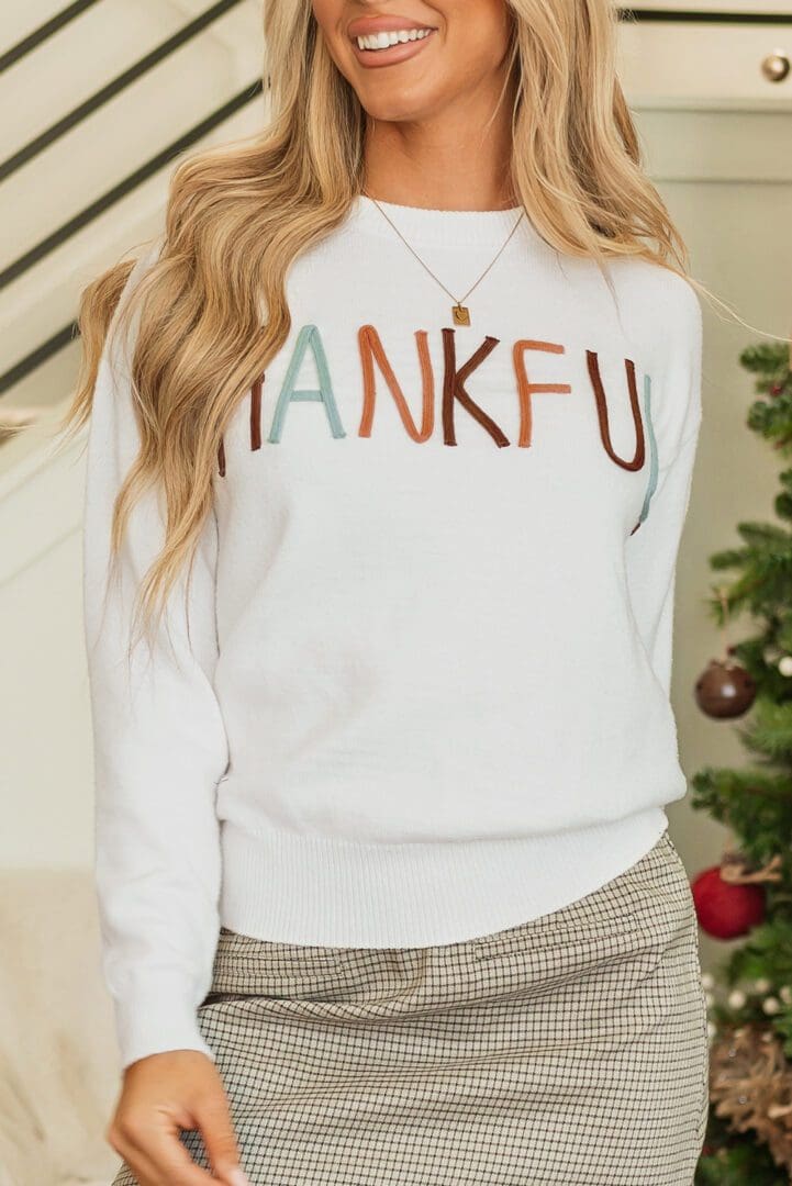 White thankful sweater with colored lettering.