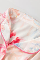 A close up of the pink and white floral pattern on a blanket.