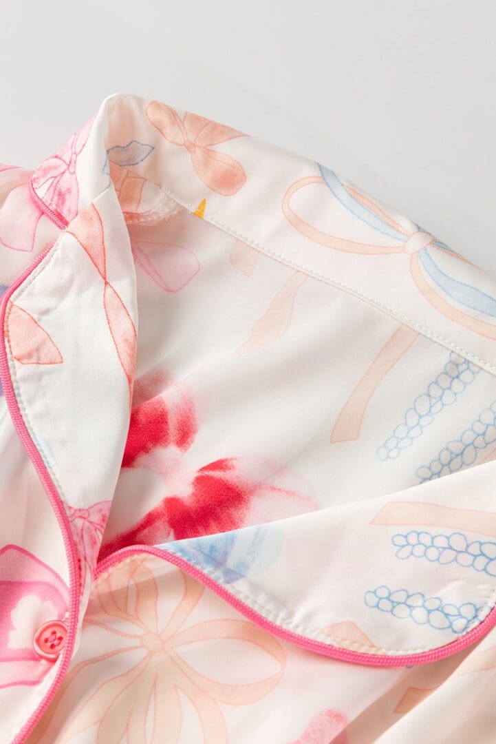 A close up of the pink and white floral pattern on a blanket.