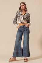 A woman in jeans and striped shirt standing on top of a platform.