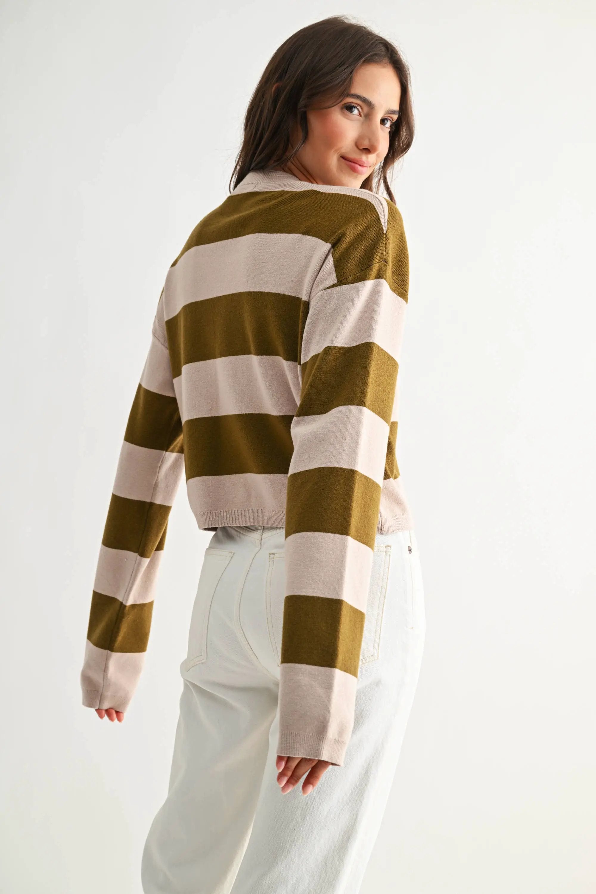 Model wearing light taupe and olive bold stripe crewneck sweater with wide horizontal stripes.