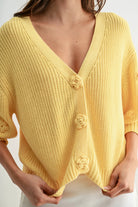 LT.YELLOW textured knit cardigan with 3D floral buttons, deep V-neck and rolled sleeves.