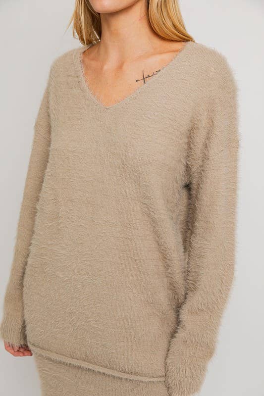 Beige fluffy V-neck sweater.