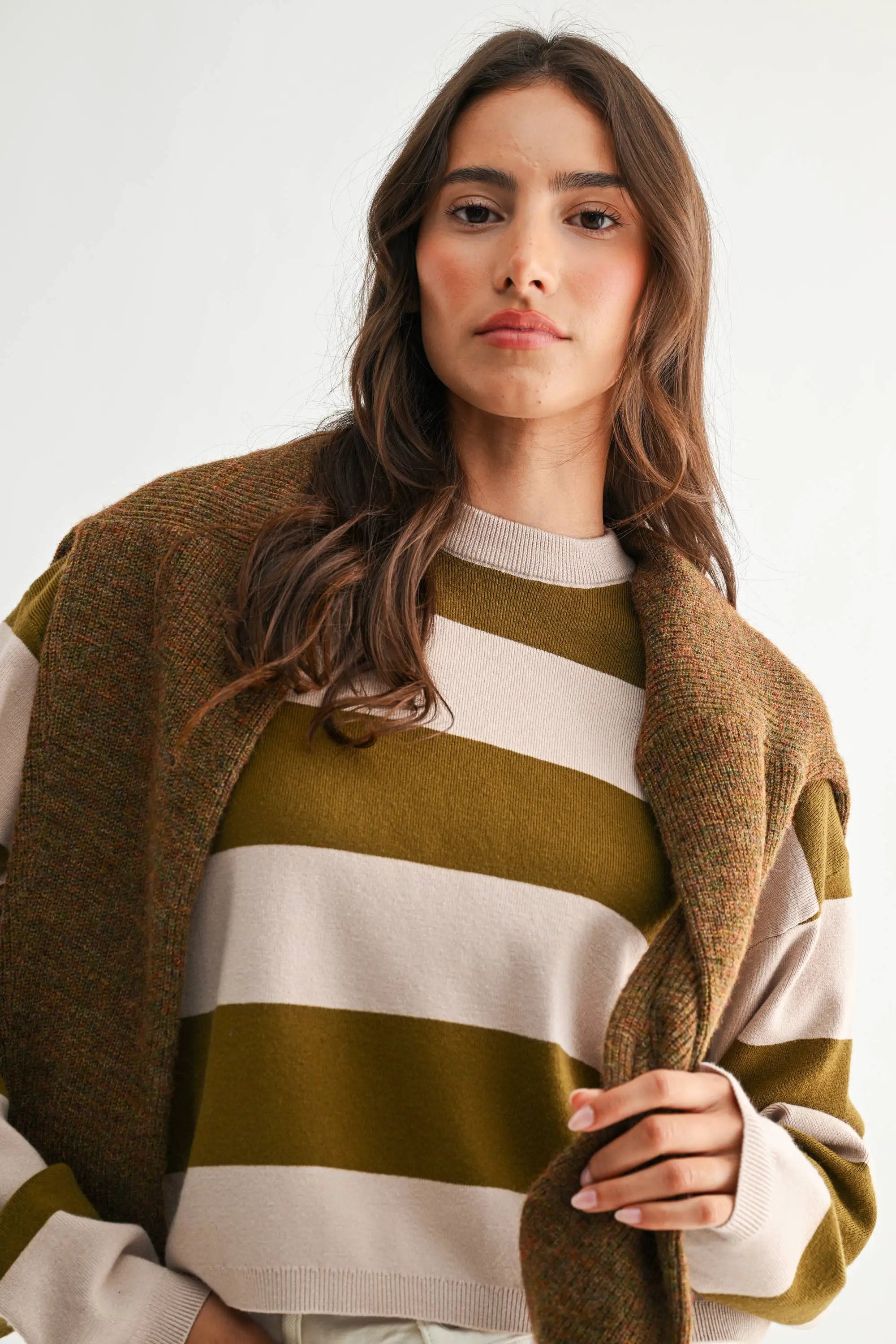 Light taupe and olive lightweight bold stripe crewneck sweater on model with brown tweed coat.