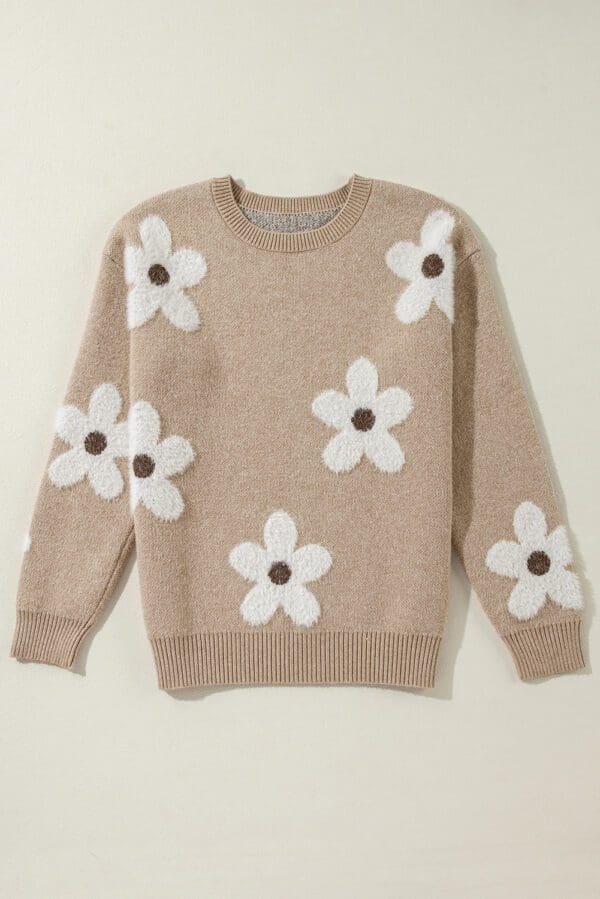 A tan sweater with white flowers on it.