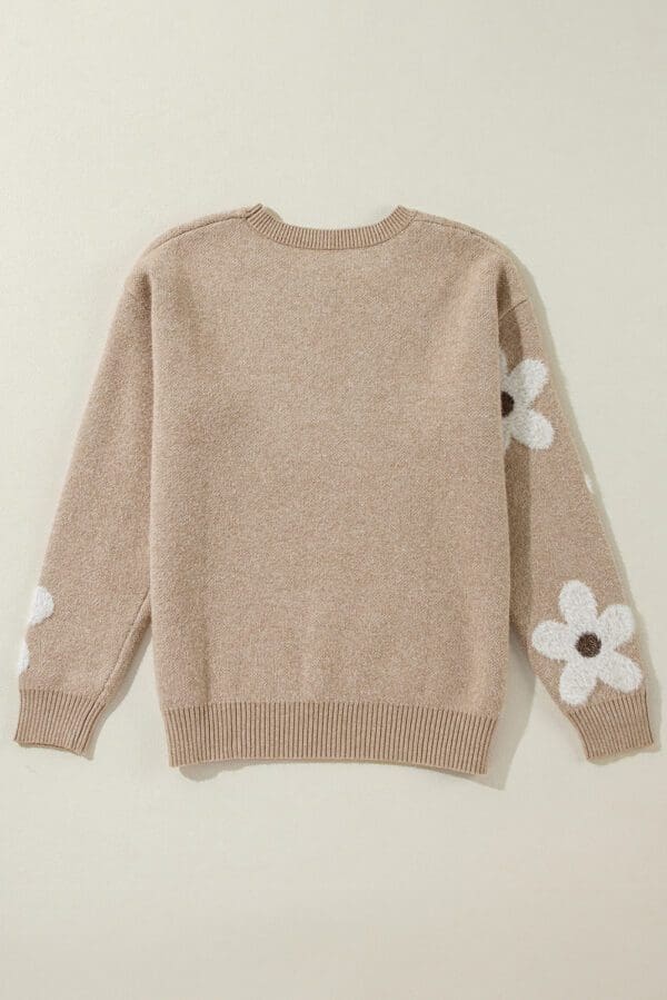 A sweater with white flowers on it.