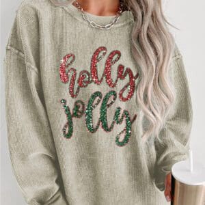 A woman wearing a sweatshirt that says " holly jolly ".