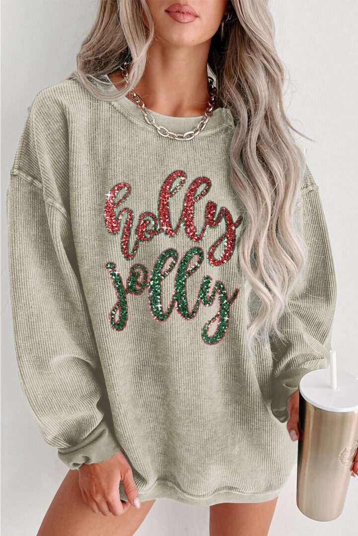 A woman wearing a sweatshirt that says " holly jolly ".