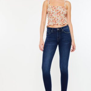 A woman wearing skinny jeans and floral top.