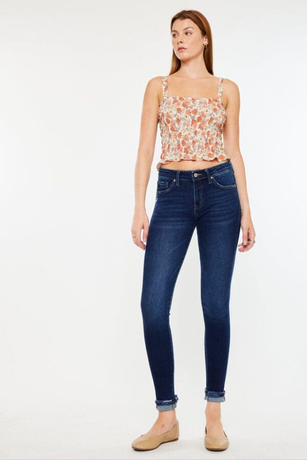 A woman wearing skinny jeans and floral top.