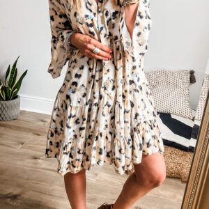 A woman standing in front of a mirror wearing a dress.