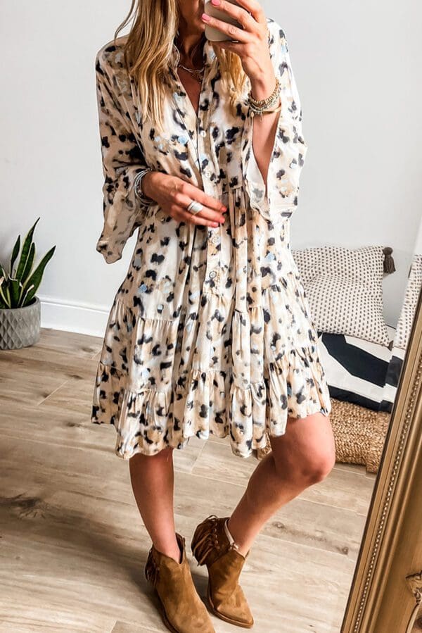 A woman standing in front of a mirror wearing a dress.