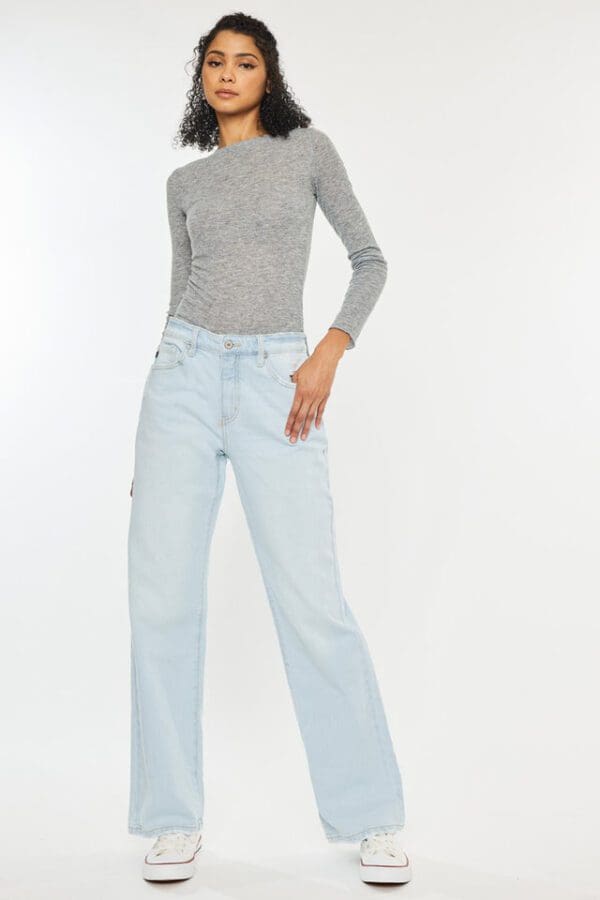 A woman in grey shirt and light blue jeans.