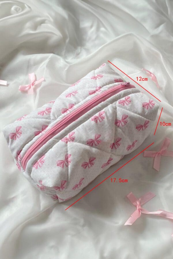 A white and pink bag with bows on it