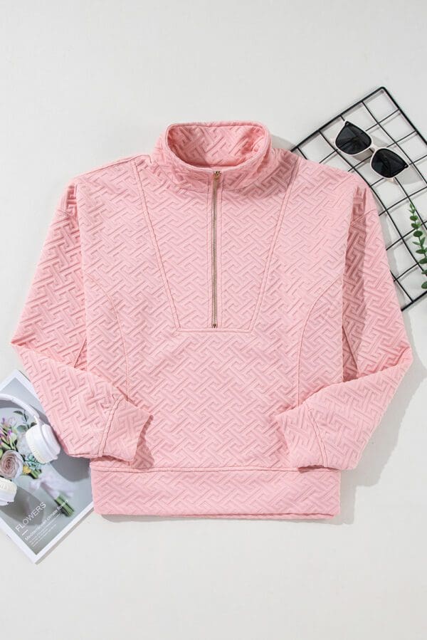 A pink sweater with a zipper on the front.