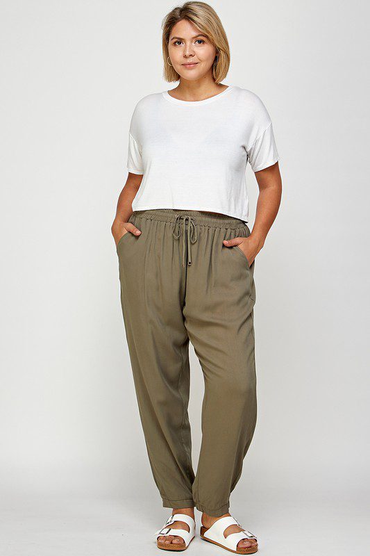 Woman in white top and olive pants.