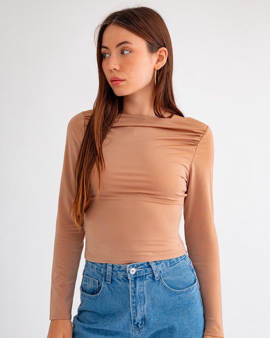 Woman in nude long-sleeve top and jeans.