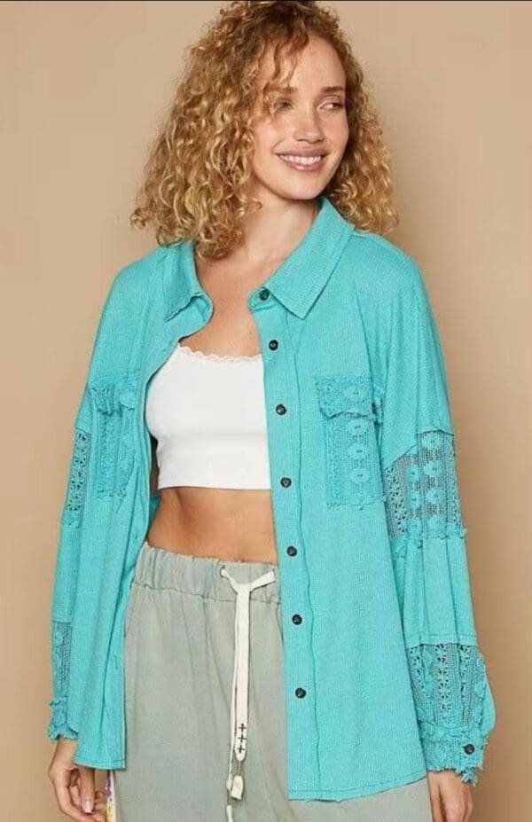 Teal lace-trimmed button-up shirt.