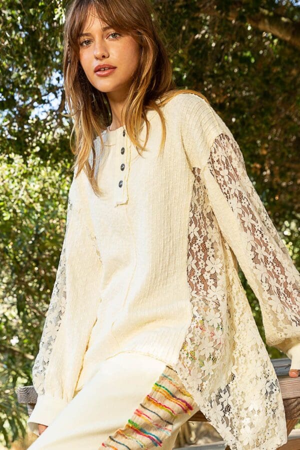 Cream lace-sleeve sweater, model.