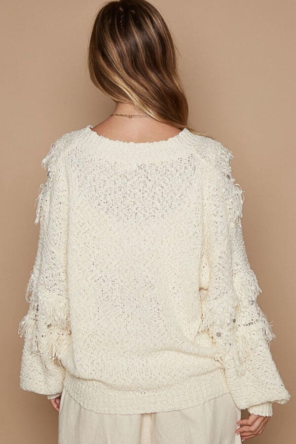 Cream fringe detail knit sweater back.