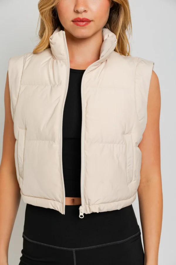 Cream sleeveless puffer vest, zippered.